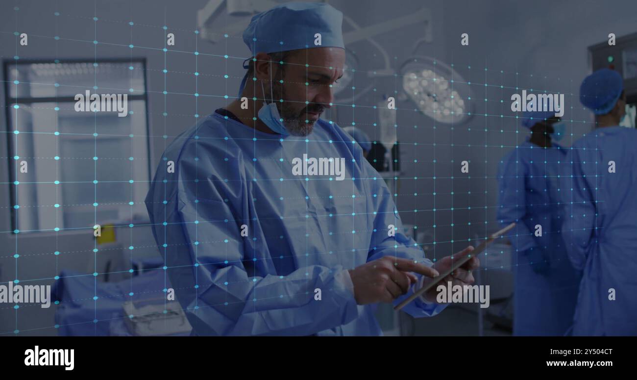 Médecin utilisant la tablette dans la salle d'opération, image de fréquence cardiaque sur le personnel médical Banque D'Images