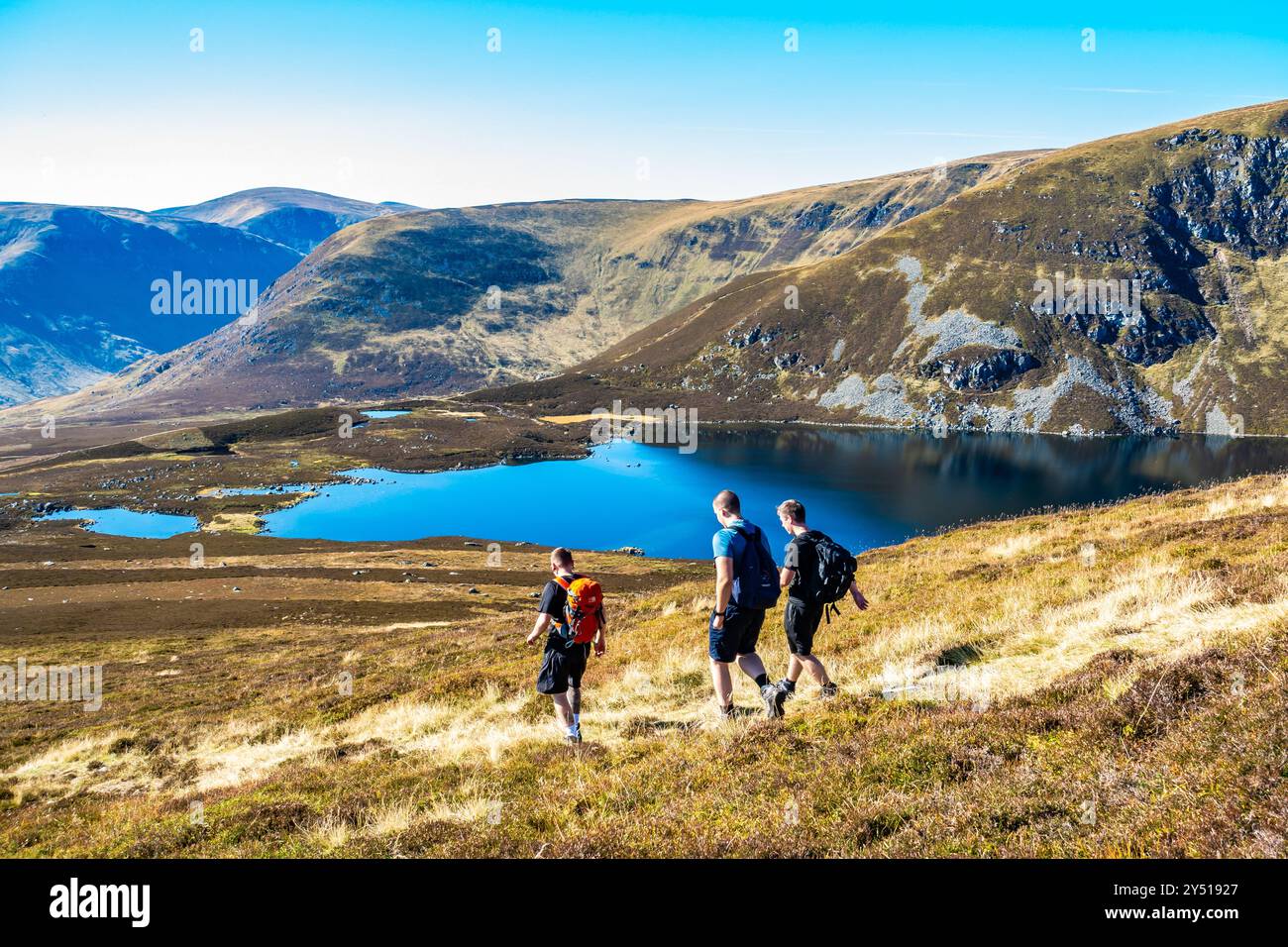 Trois marcheurs sur le chemin de Green Hill au-dessus du Loch Brandy, un loch de montagne à Glen Clova, Angus, Écosse Banque D'Images