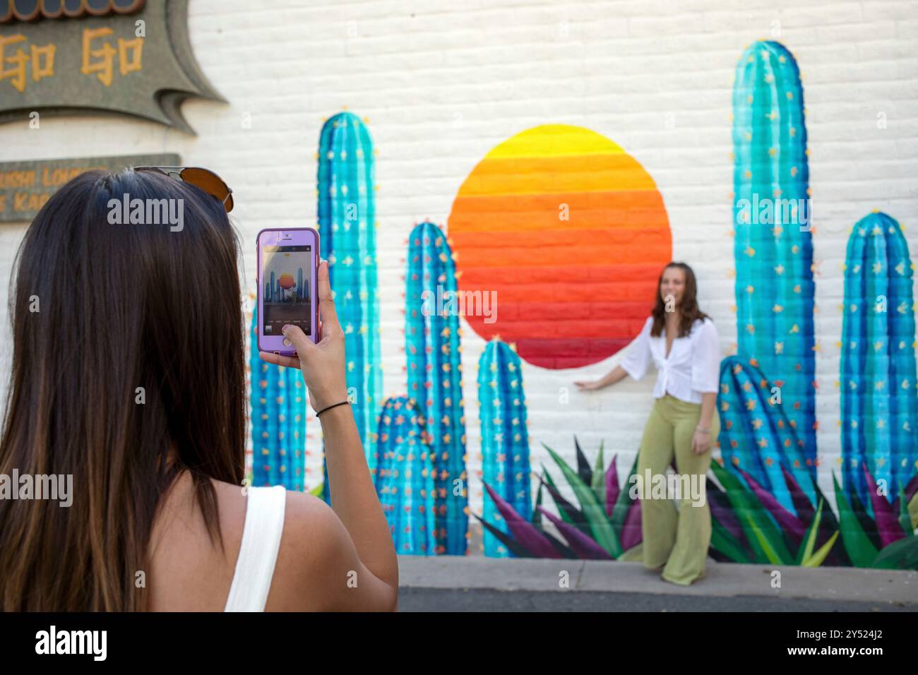 De jeunes femmes prennent des photos devant une murale à Scottsdale Banque D'Images