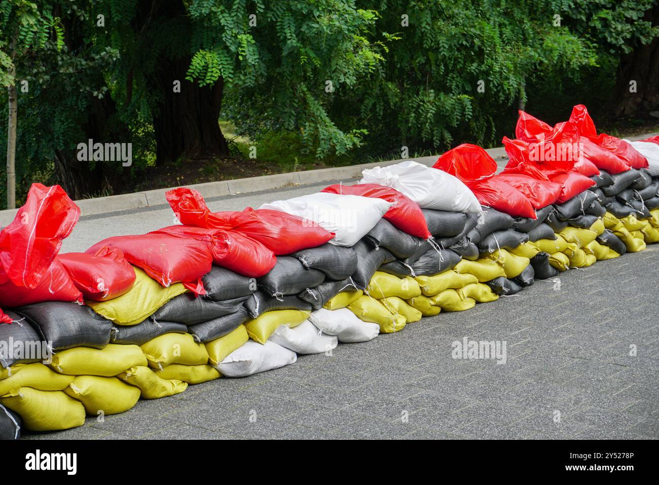 Un grand tas de sacs de sable, principalement rouges avec quelques blancs, disposés pour le contrôle des inondations ou le ballast. Banque D'Images