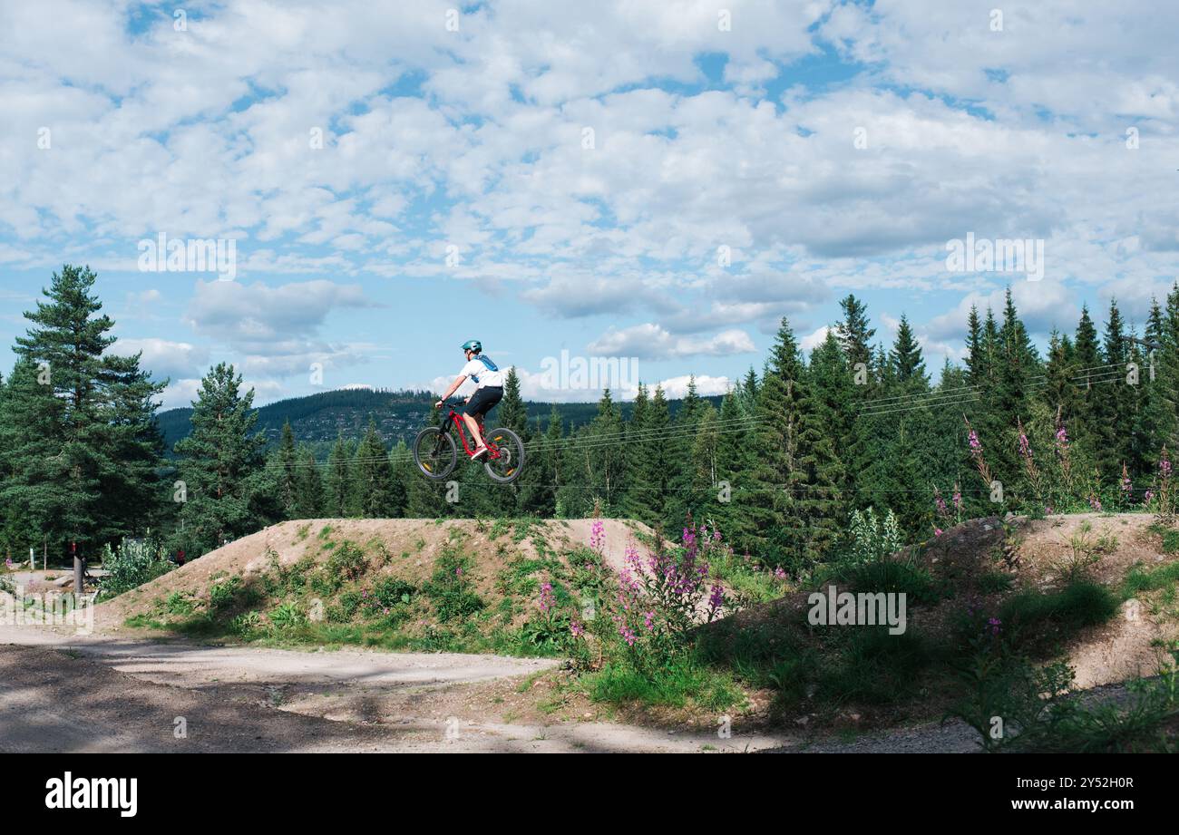 homme faisant un saut alors qu'à un parc à vélo dans la montagne Banque D'Images