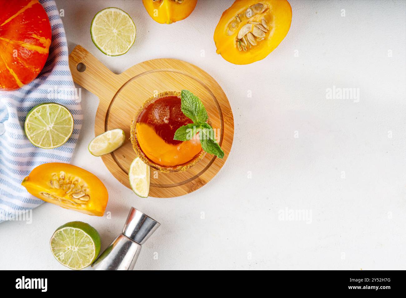 Margarita de Thanksgiving, cocktail d'arbustes de citrouille douce, boisson d'automne savoureuse à l'alcool sur fond blanc avec des tranches de citrouilles, espace de copie Banque D'Images