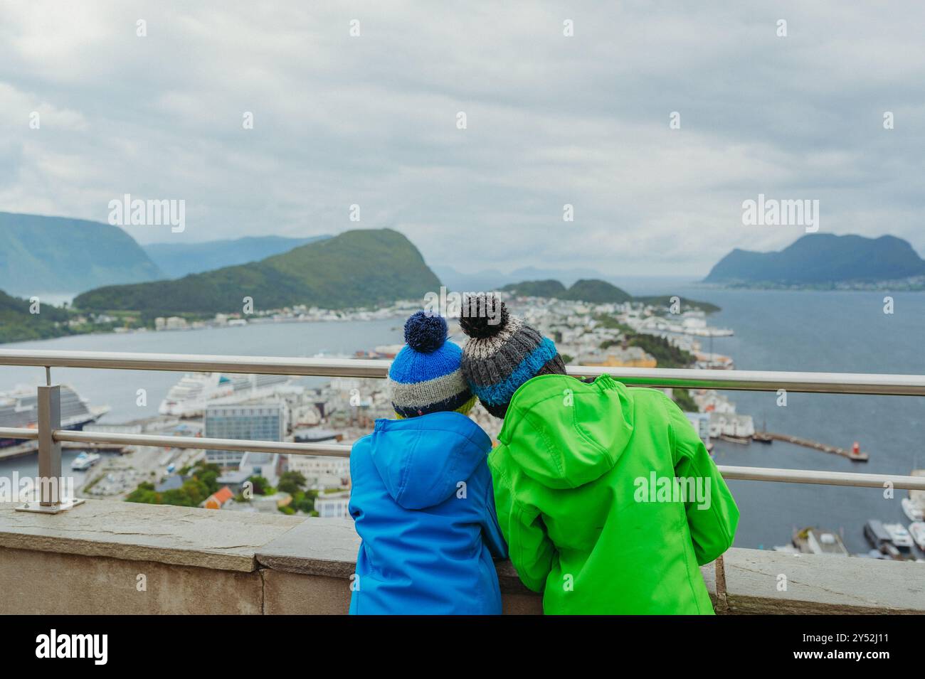 Deux garçons en tenue d'hiver surplombent la ville pittoresque de Ålesund, en Norvège Banque D'Images