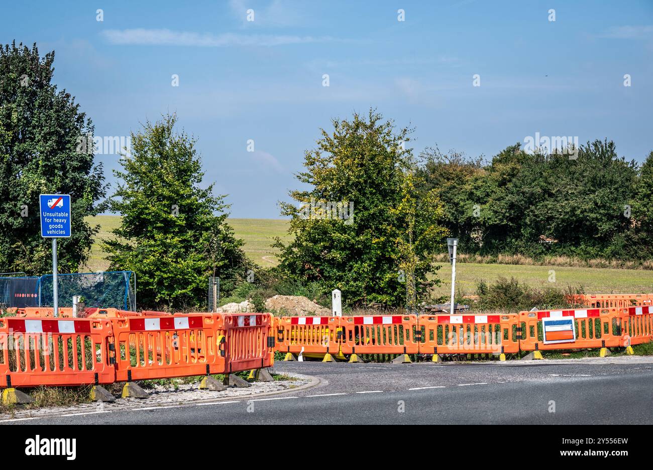 travaux routiers pour réparer, entretenir ou améliorer un revêtement routier marqué par des barrières rouges et blanches pour prévenir les accidents. Banque D'Images