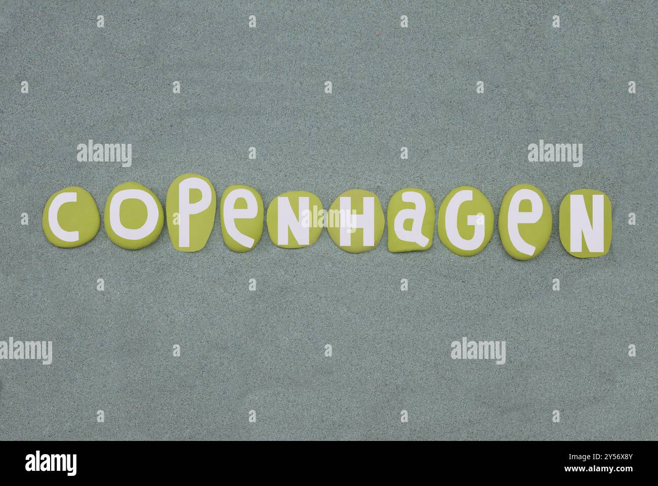 Copenhague ville principale du Danemark, design de logo créatif composé de lettres en pierre de couleur verte peintes à la main sur du sable vert Banque D'Images