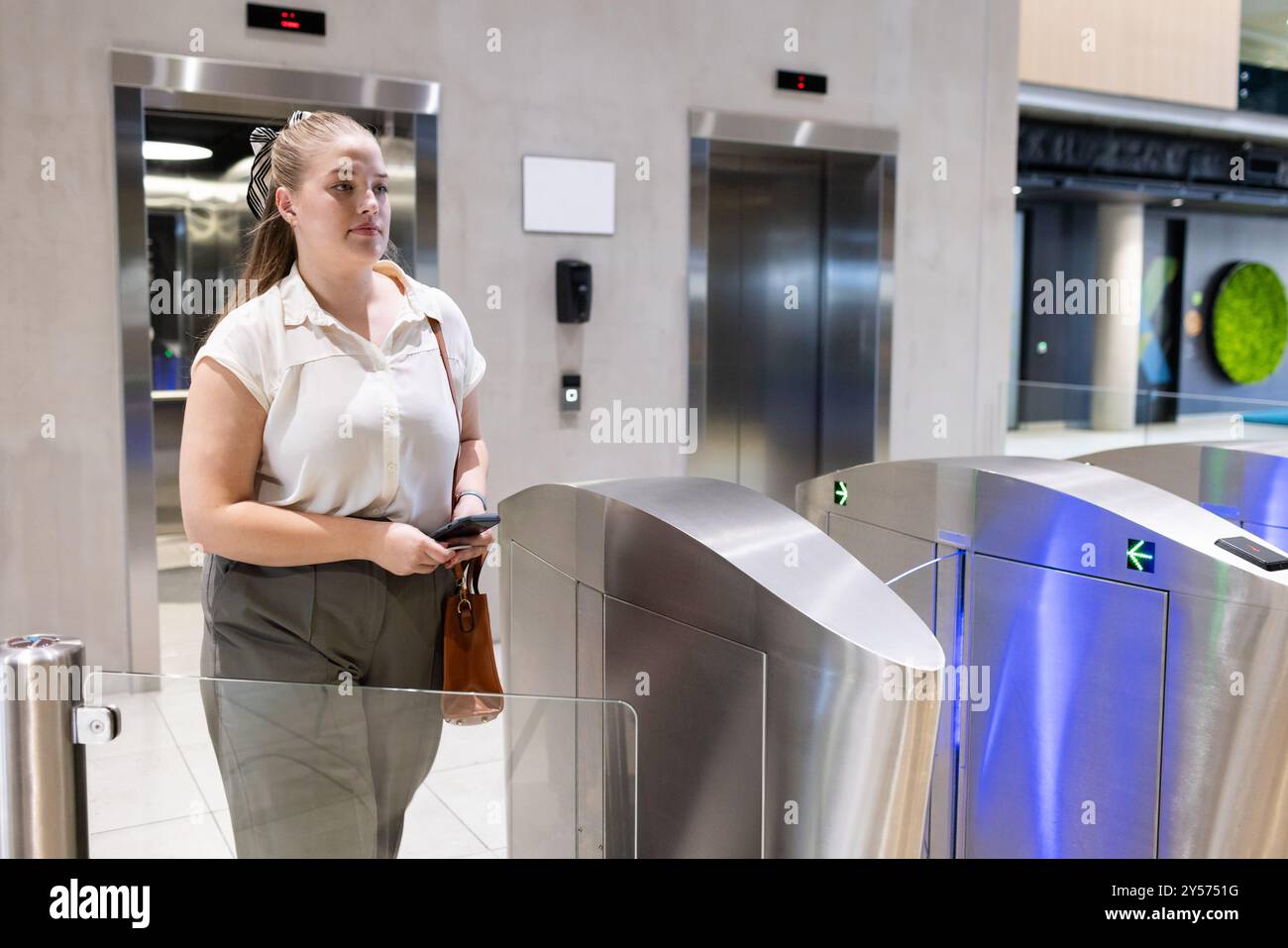 Entrée dans l'immeuble de bureaux, femme utilisant la carte d'accès au tourniquet de sécurité Banque D'Images