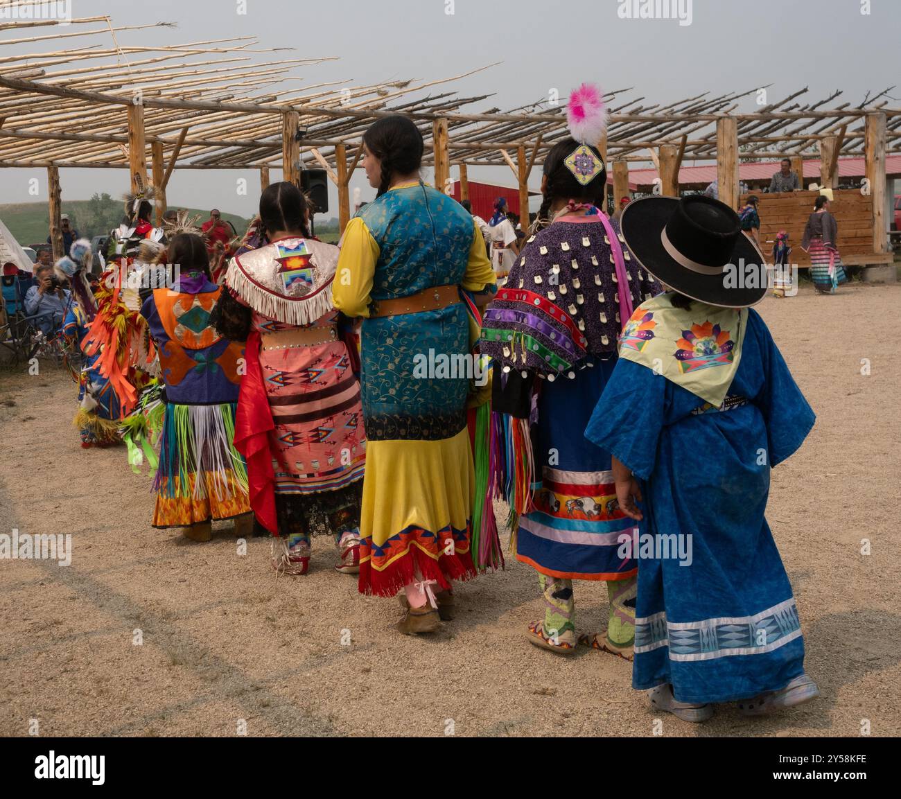 Ligne de femmes et de filles amérindiennes en plein regalia photographiées de derrière dans un pow-wow à Lodgepole, Montana. Banque D'Images