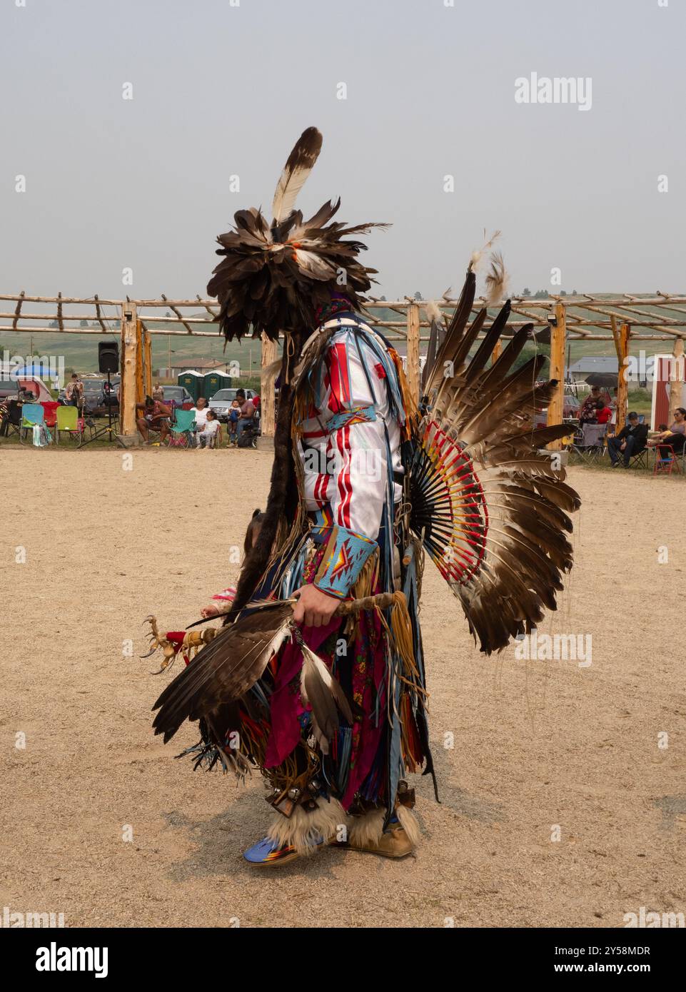 Danseur de fantaisie amérindien masculin portant une coiffe en plumes, de l'agitation, des manchettes perlées et des mocassins. Photographié au Lodgepole Pow Wow dans le Montana. Banque D'Images