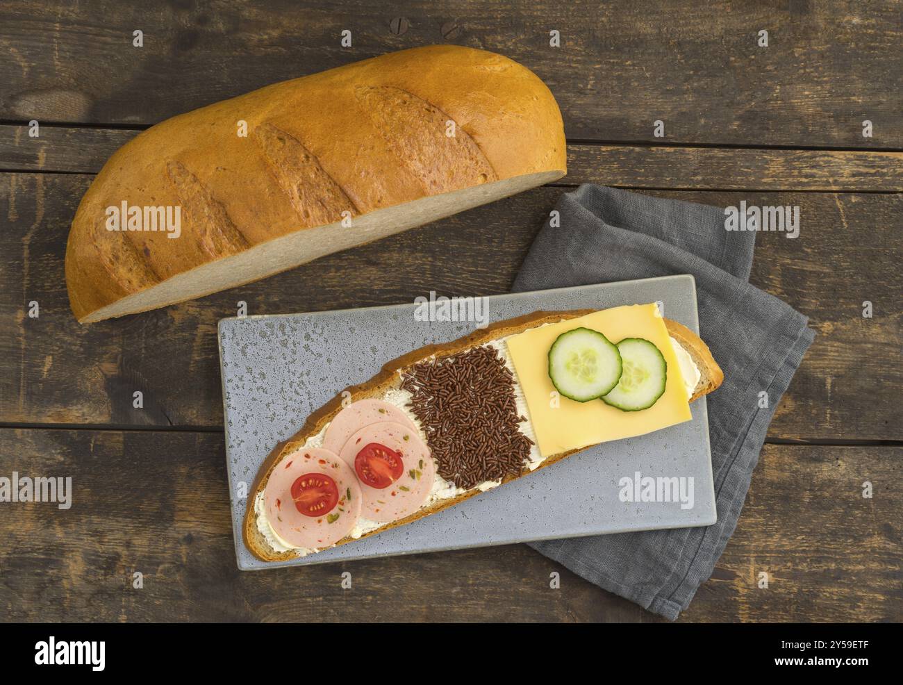 Coupe longue d'une miche de pain, trois différents sandwichs pour la famille Banque D'Images