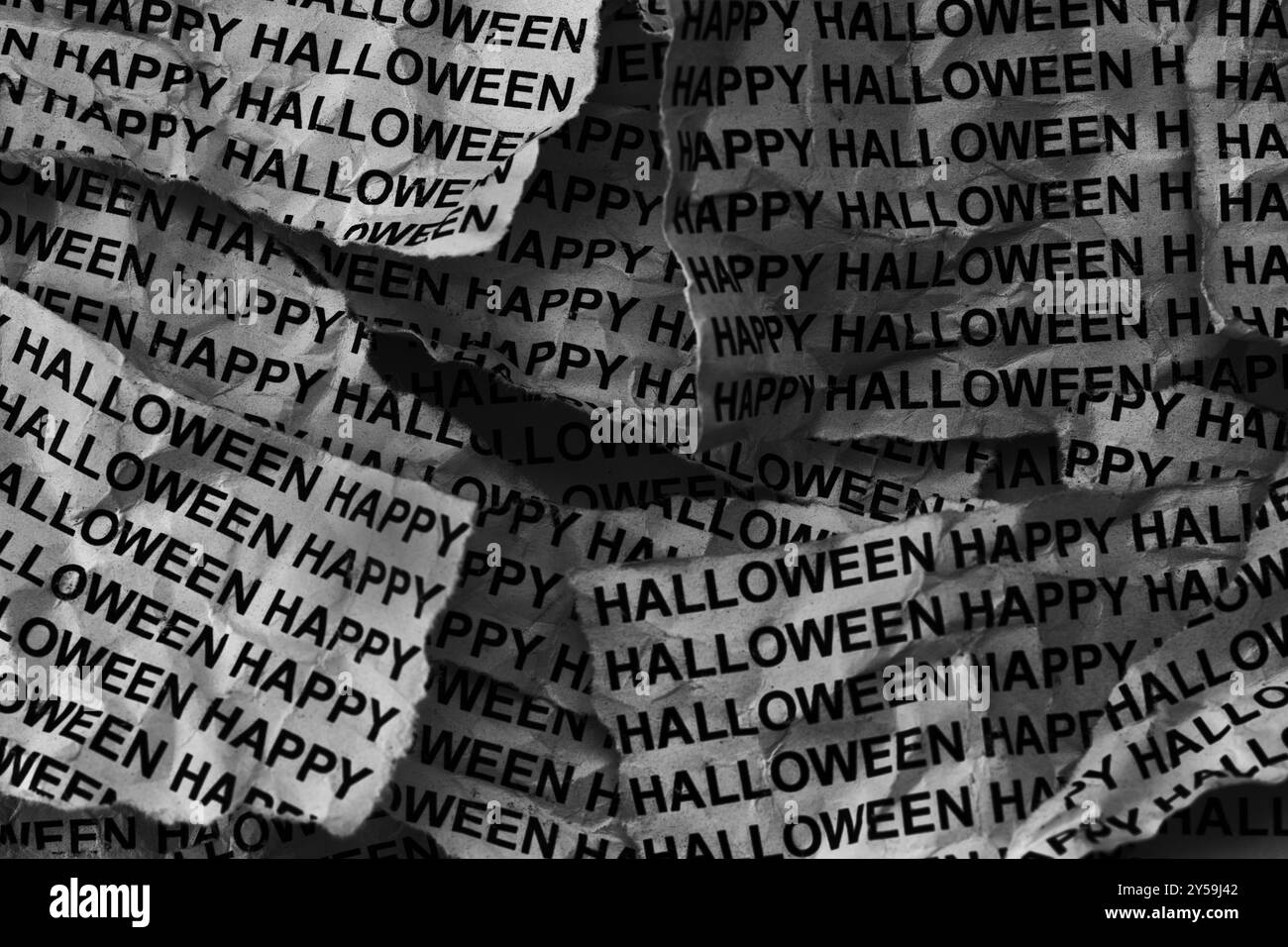 Feuilles de journal déchirées avec les mots Happy Halloween tapés dessus. Noir et blanc. Gros plan. Banque D'Images