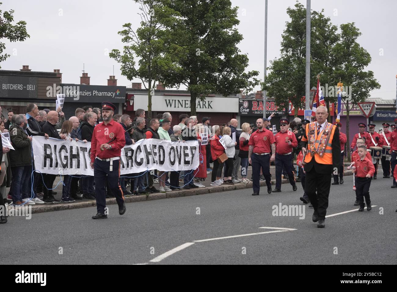 Les résidents locaux protestent alors que les membres de l'ordre Orange prennent part à un défilé de Woodvale Road le long de Crumlin Road en passant par les magasins Ardoyne à Belfast. Date de la photo : samedi 21 septembre 2024. Banque D'Images