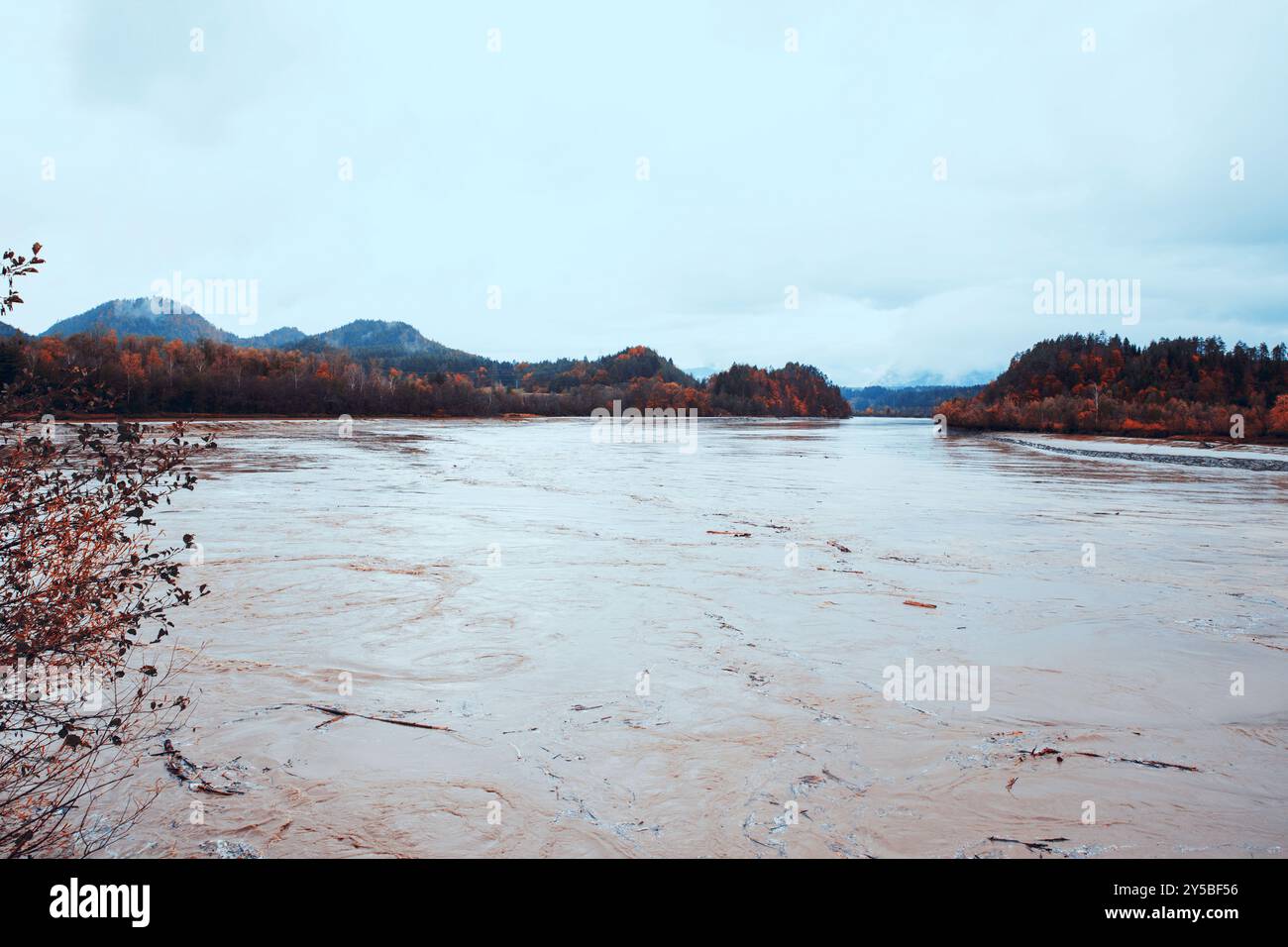 Rivière coulant majestueusement à travers un paysage de montagne, feuillage d'automne, concept de tranquillité de l'eau Banque D'Images