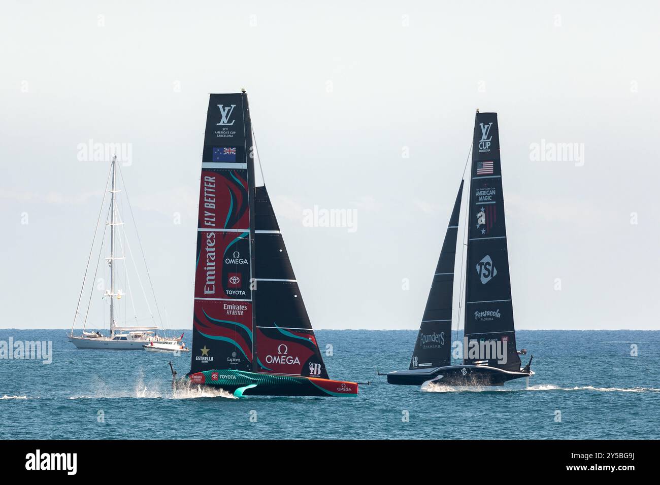 Barcelone, Espagne - 9 septembre 2024 : les équipes de voile Emirates Nouvelle-Zélande et American Magic race se sont croisées sur des voiliers de foiling en préparati Banque D'Images