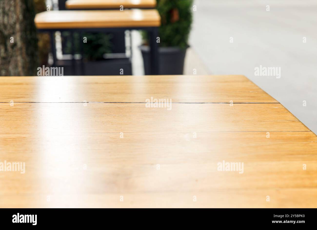 Tables en bois vides dans un café extérieur urbain, surfaces propres prêtes pour les clients, sièges dans la rue de la ville, ambiance rafraîchissante, concept de style moderne Banque D'Images