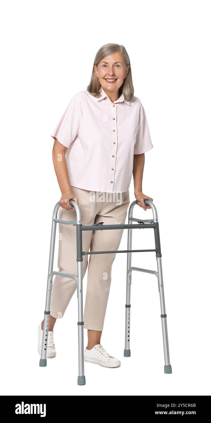 Femme senior utilisant le cadre de marche sur fond blanc Banque D'Images