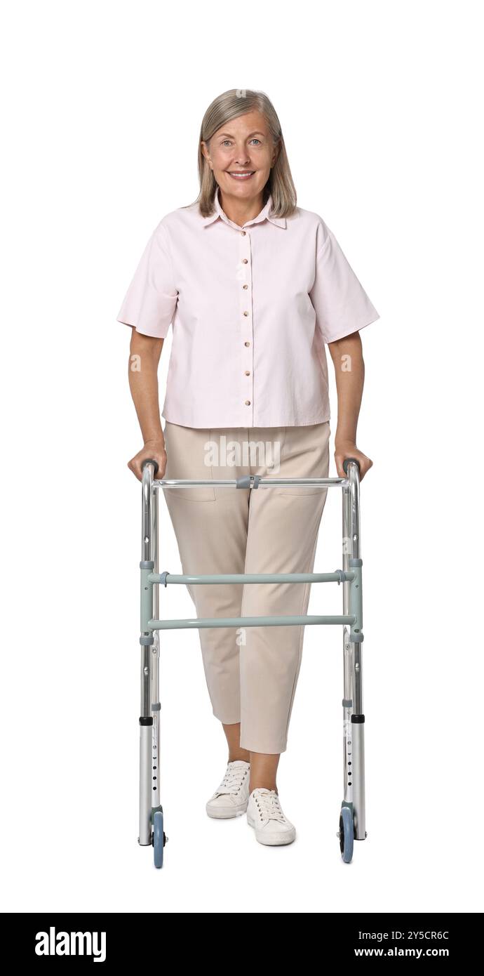 Femme senior utilisant le cadre de marche sur fond blanc Banque D'Images