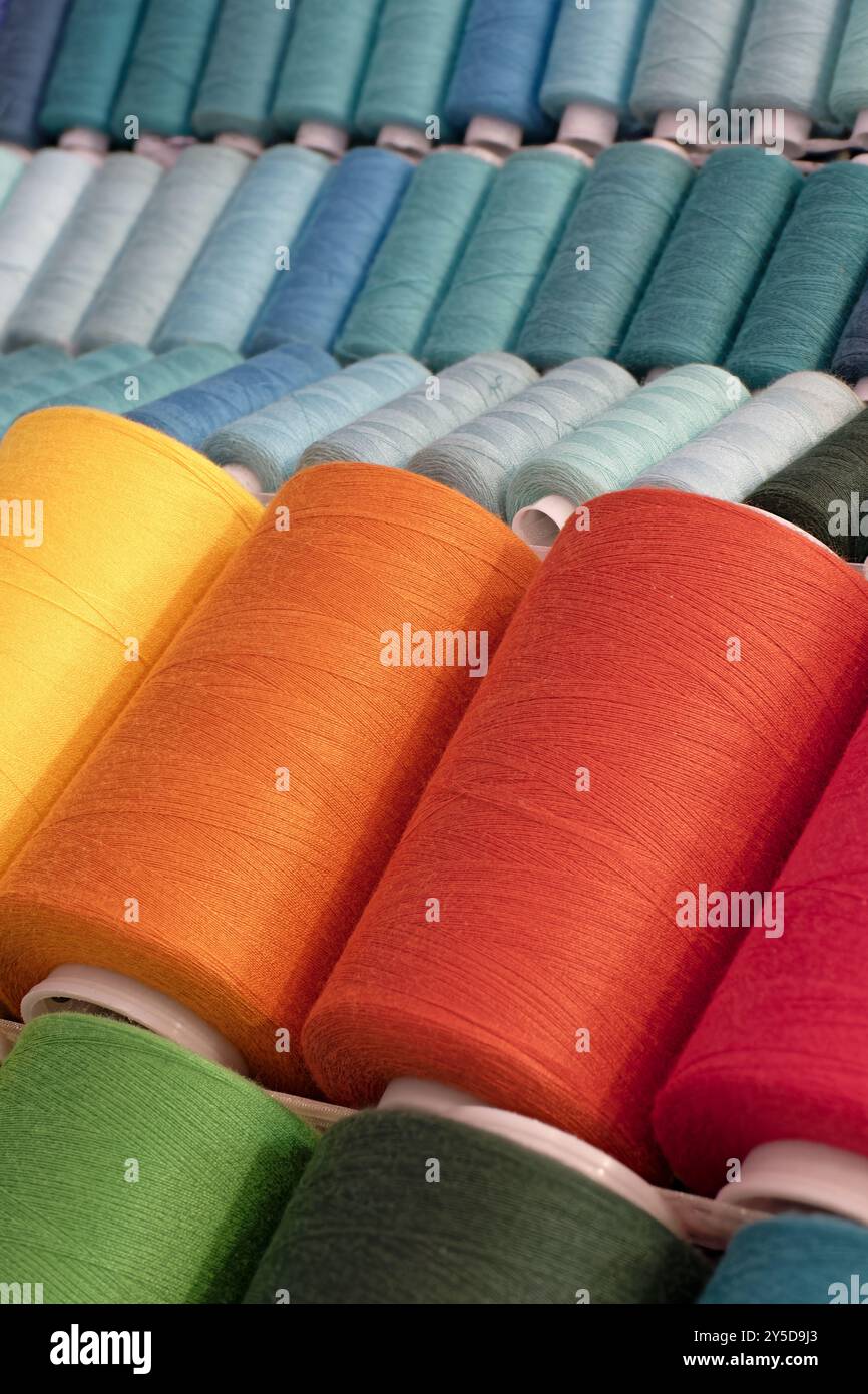 Bobines de fils de coton multicolores, fond abstrait de l'industrie textile Banque D'Images