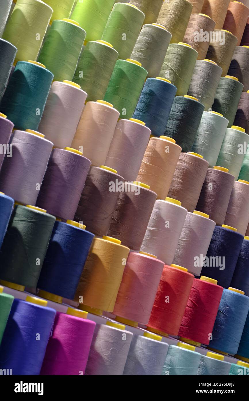 Bobines de fils de coton multicolores, fond abstrait de l'industrie textile Banque D'Images