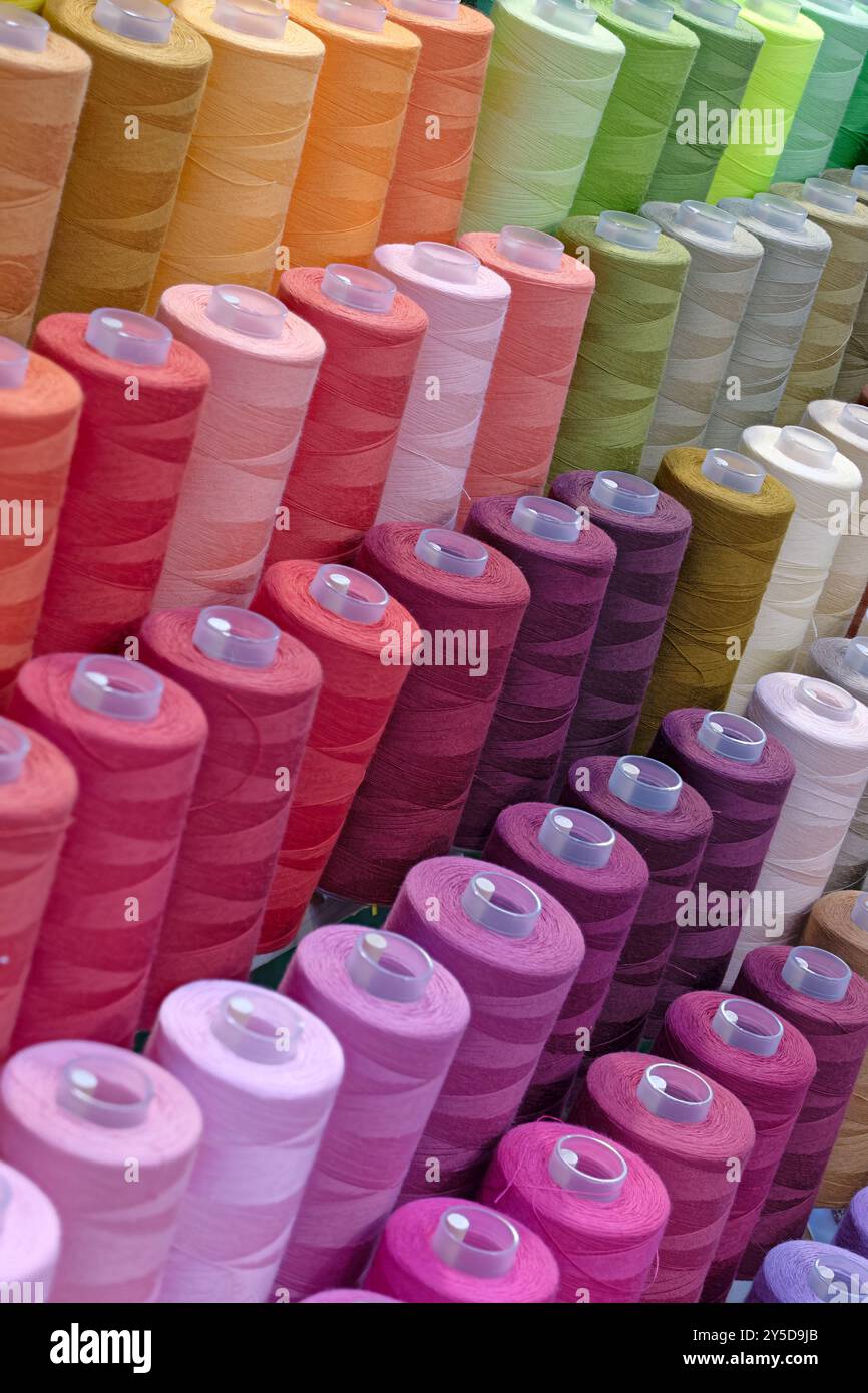 Bobines de fils de coton multicolores, fond abstrait de l'industrie textile Banque D'Images
