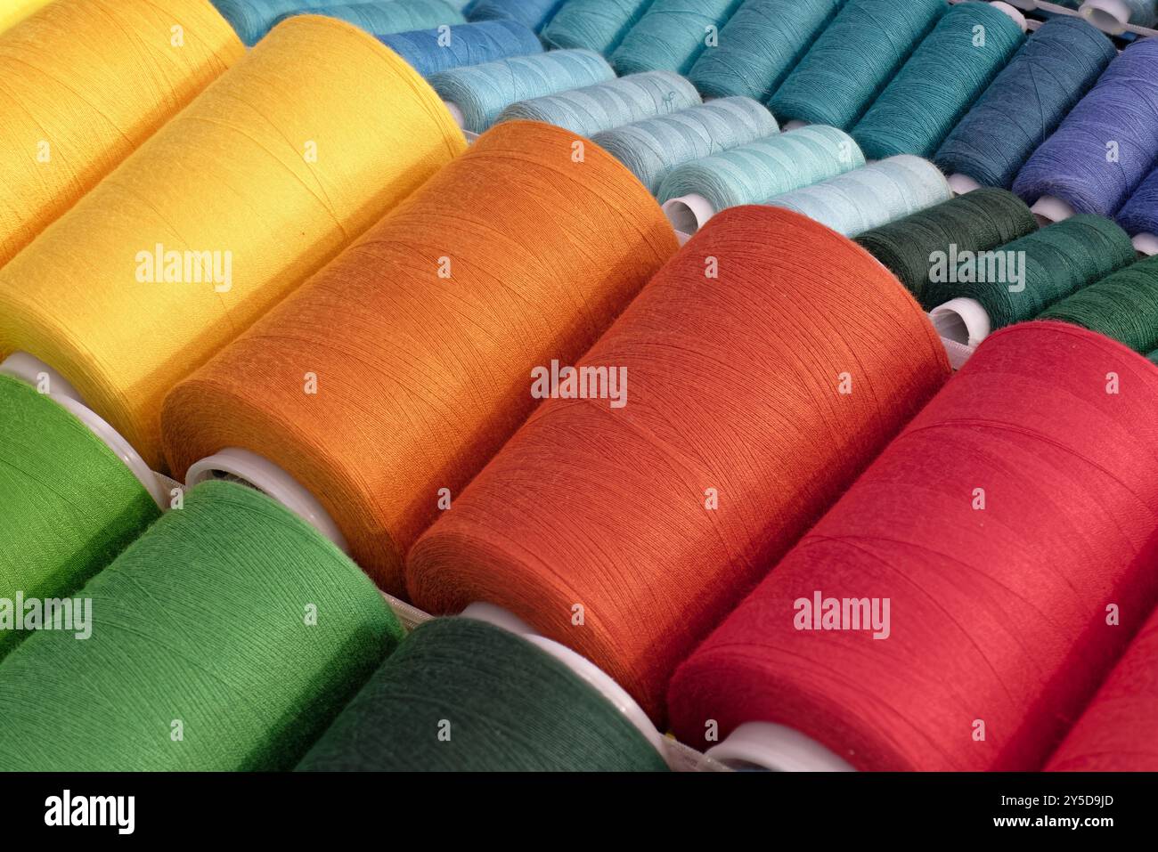 Bobines de fils de coton multicolores, fond abstrait de l'industrie textile Banque D'Images