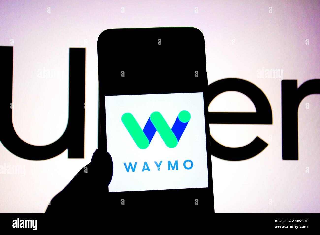 Inde. 19 septembre 2024. Dans cette illustration photo, un logo Waymo vu affiché sur un smartphone avec un logo UBER en arrière-plan. (Photo par Avishek Das/SOPA images/SIPA USA) *** strictement à des fins d'actualités éditoriales *** crédit : SIPA USA/Alamy Live News Banque D'Images