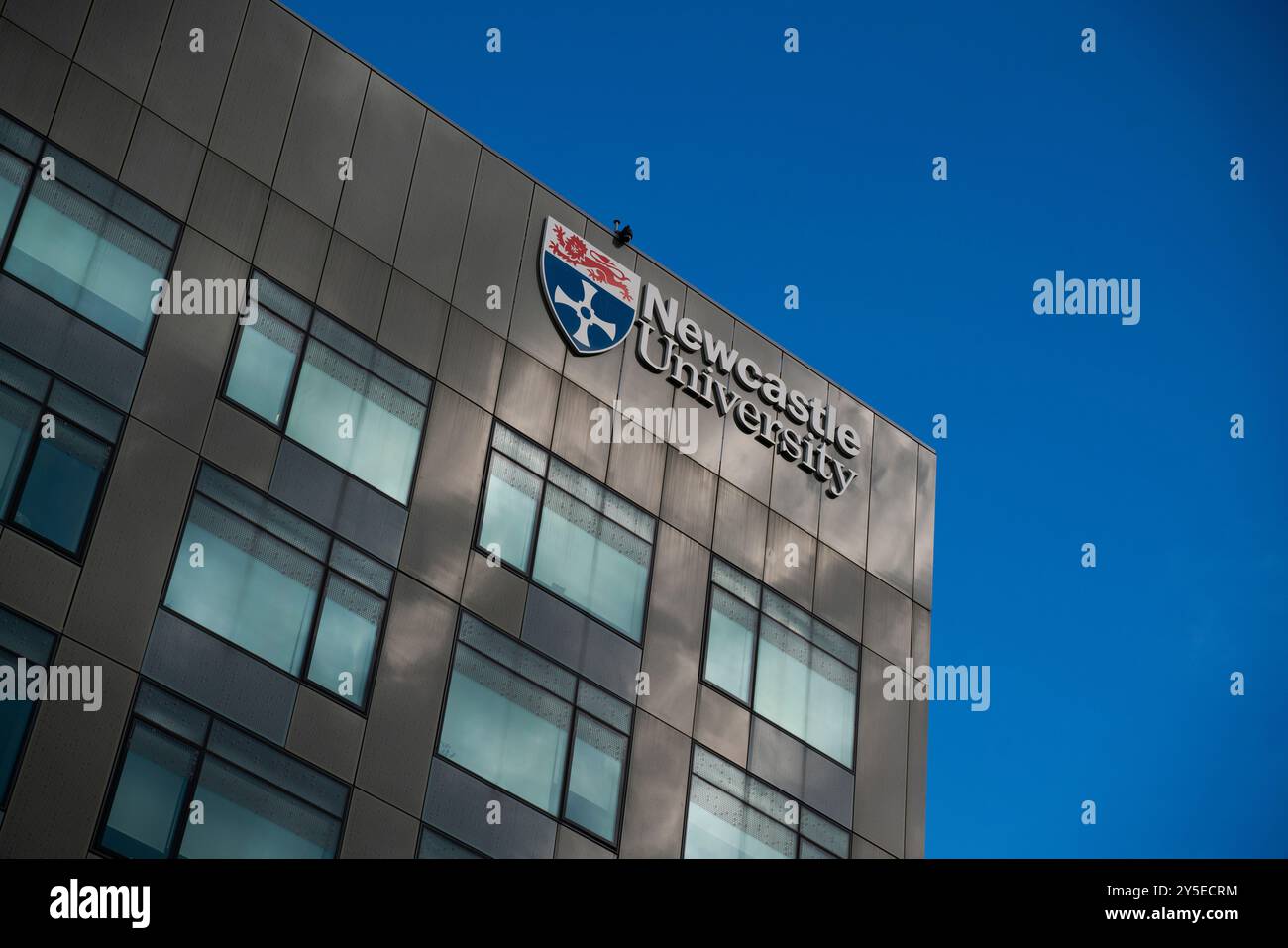 Vue générale d'un bâtiment de l'Université de Newcastle avec le logo et l'écusson de l'Université de Newcastle affichés comme un signe lors d'une journée ensoleillée. Banque D'Images