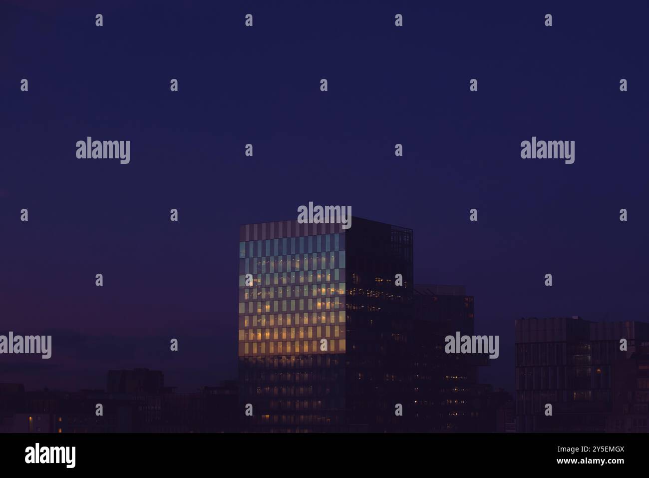 Un coucher de soleil doré se reflète au crépuscule dans les fenêtres d'un immeuble de bureaux dans le centre de Manchester. Banque D'Images