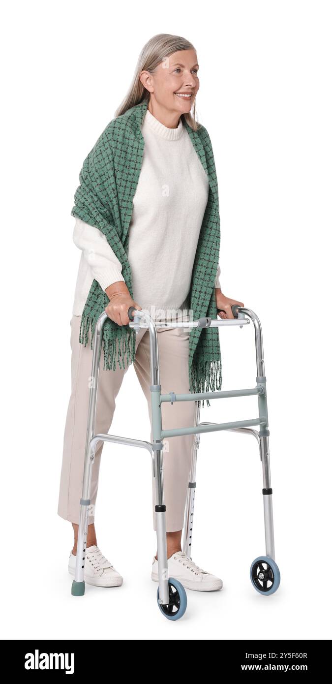 Femme senior utilisant le cadre de marche sur fond blanc Banque D'Images