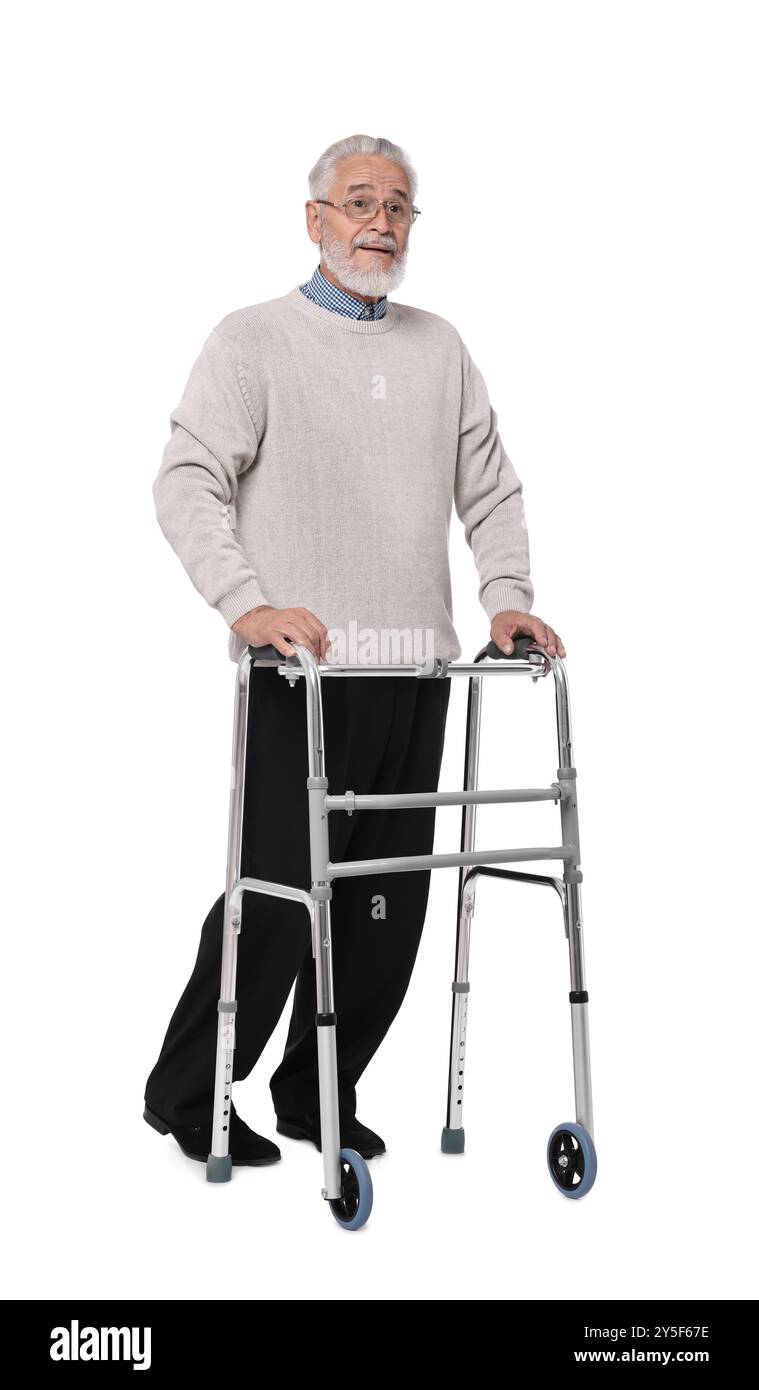 Homme senior utilisant le cadre de marche sur fond blanc Banque D'Images