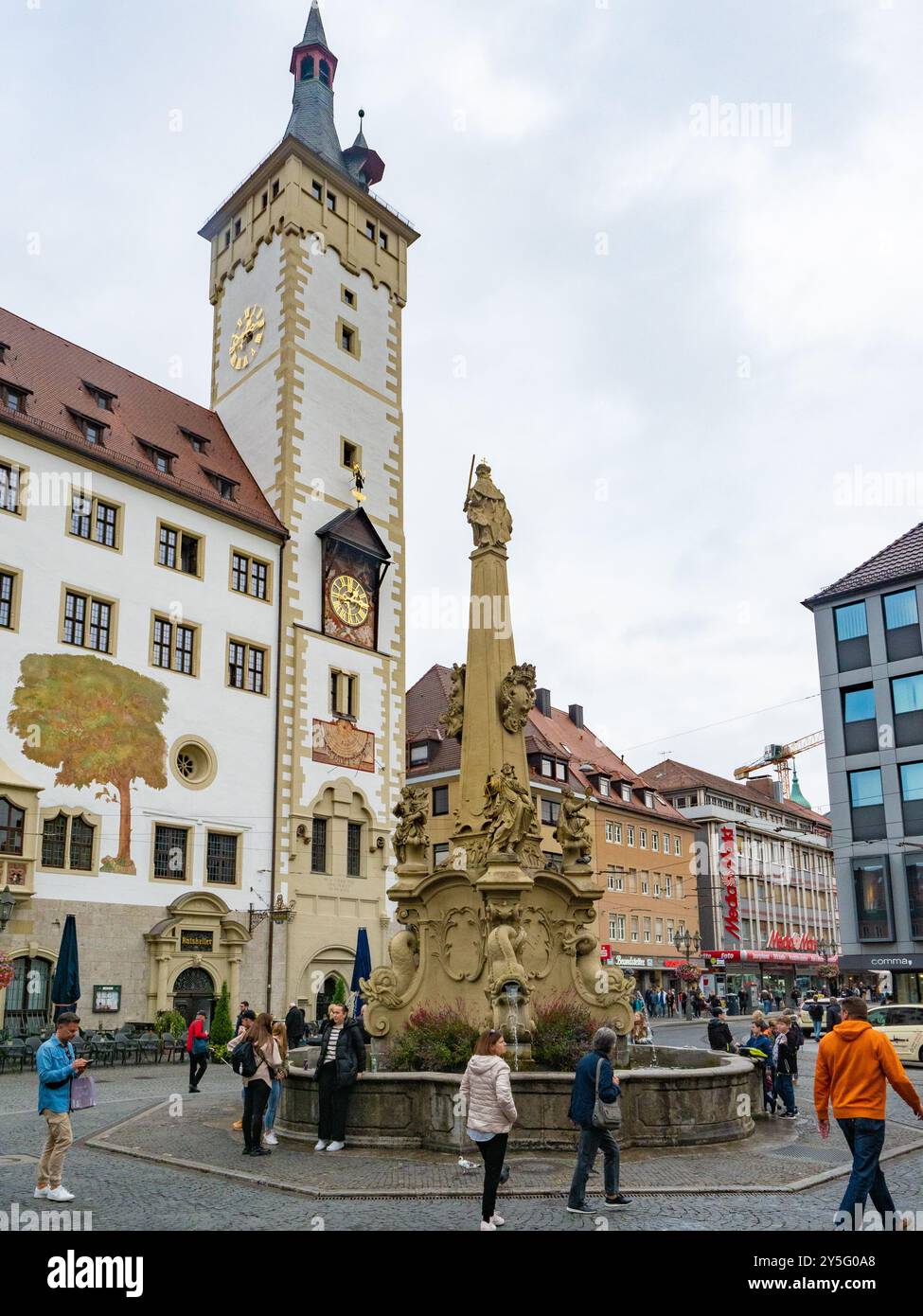Würzburg, Allemagne - 19 octobre 2023 : les gens autour d'une vieille fontaine avec obélisques dans le centre historique de la ville. Banque D'Images