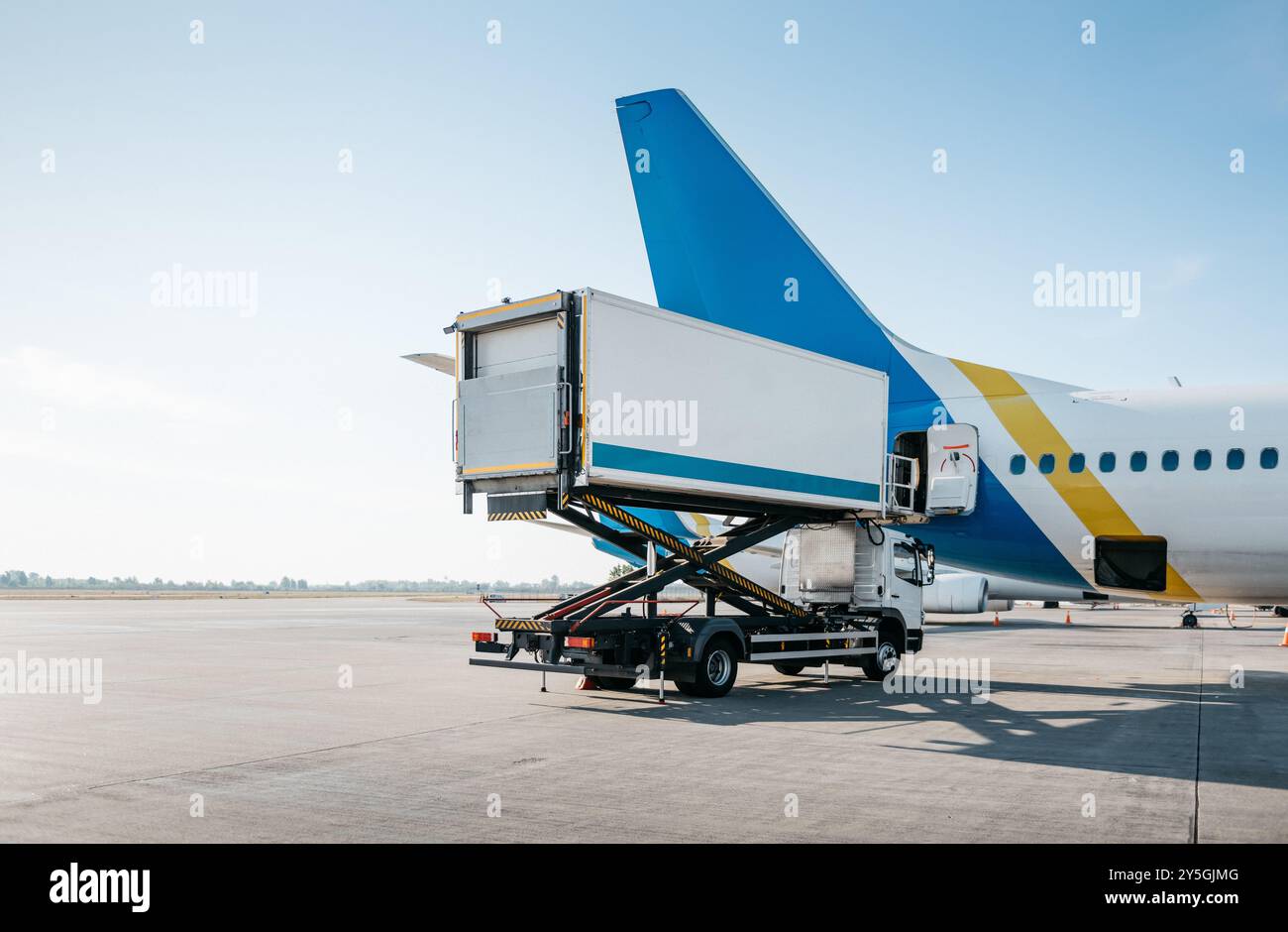 Camion traiteur à proximité d'un jet de passagers. Avion en préparation pour un vol. Voie de circulation et piste vides en arrière-plan. Banque D'Images