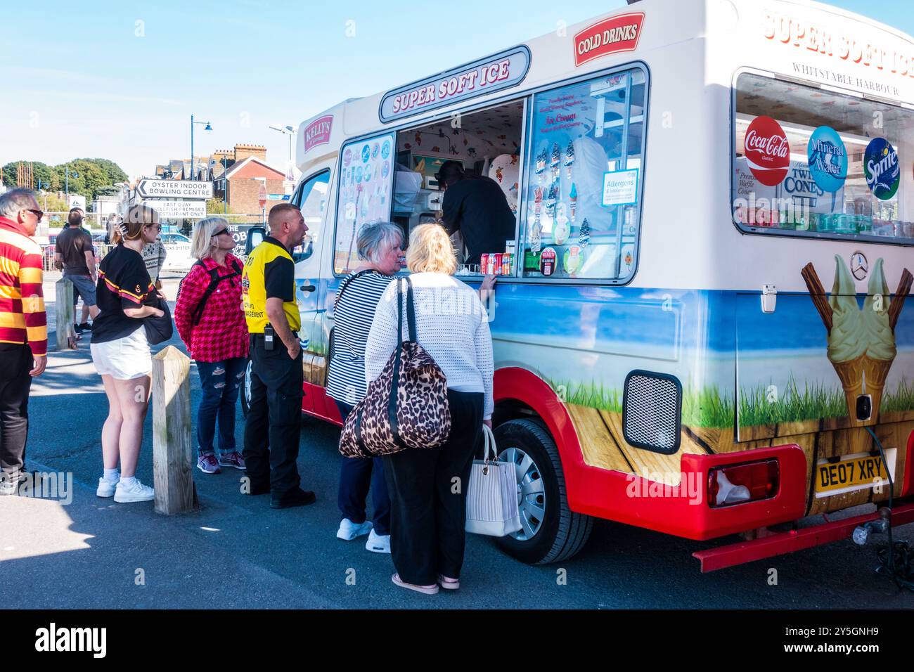 Fourgonnette de crème glacée servant des adultes en bord de mer côtière par une journée ensoleillée Banque D'Images