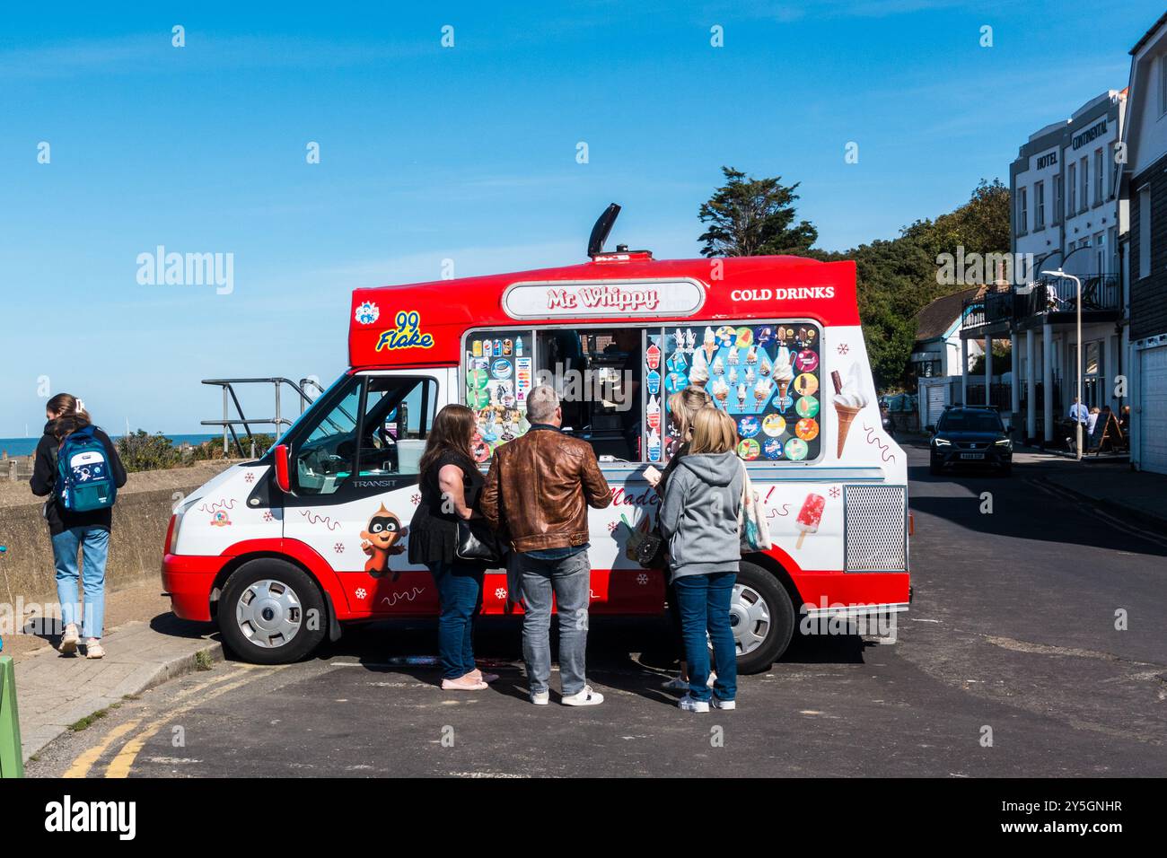 Fourgonnette de crème glacée servant des adultes en bord de mer côtière par une journée ensoleillée Banque D'Images