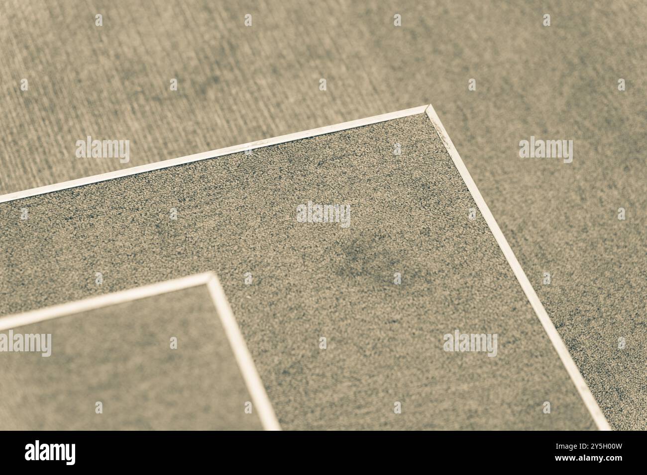 Terrain de tennis abstrait : surface de tapisserie verte avec bords blancs et sol sale. Banque D'Images