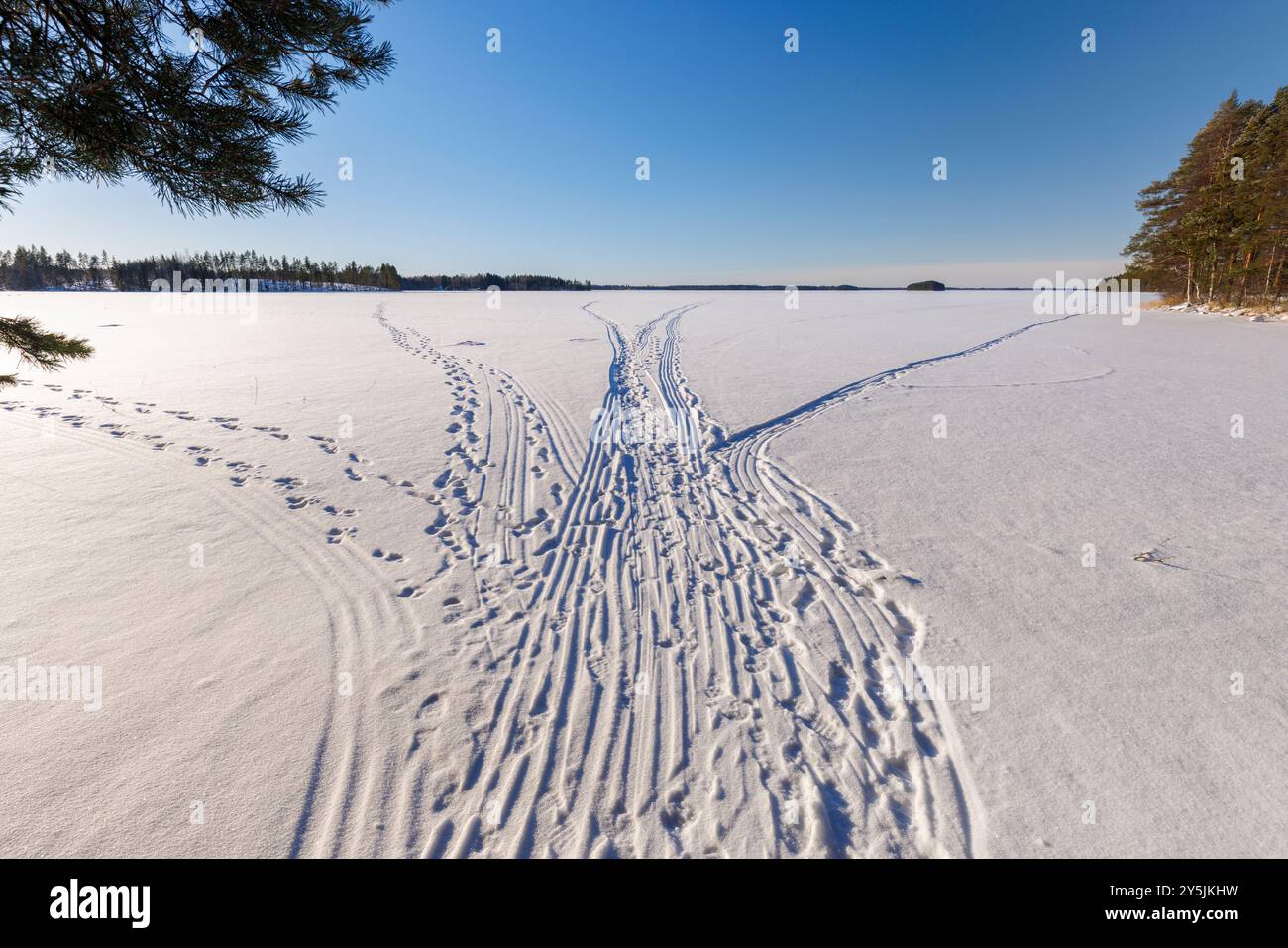 Pistes de motoneige et sentiers humains jusqu'à la glace du lac Etelä-Niinivesi à Winter, Finlande Banque D'Images