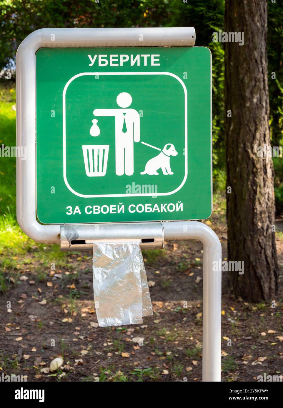 Un stand avec des sacs pour nettoyer après les animaux dans le parc. Traduction de l'inscription : 'nettoyer après votre chien' Banque D'Images