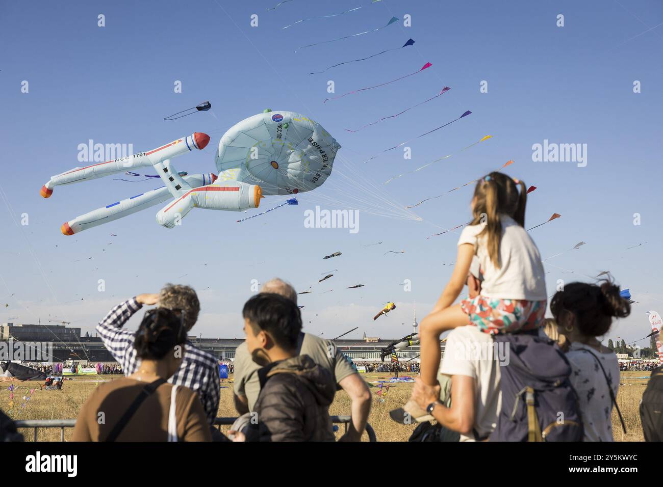 Les visiteurs regardent des cerfs-volants volants, y compris sous la forme de l'USS Enterprise, devant la tour de télévision de Berlin lors du festival de cerfs-volants sur Tempelhofer Feld In Banque D'Images
