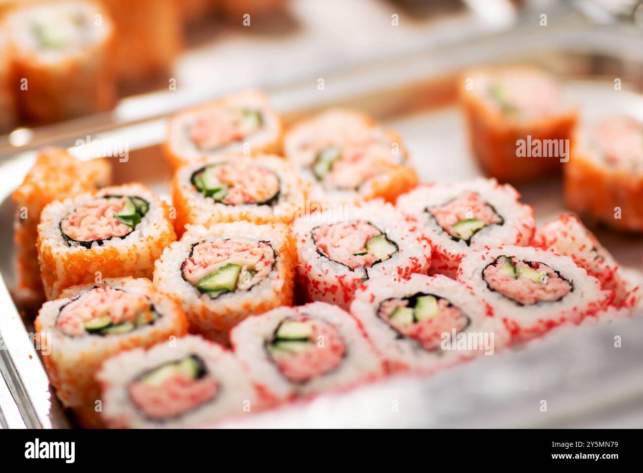 Un plateau de sushis magnifiquement arrangé avec un délicieux crabe et du concombre frais placé avec art dessus pour le plaisir Banque D'Images