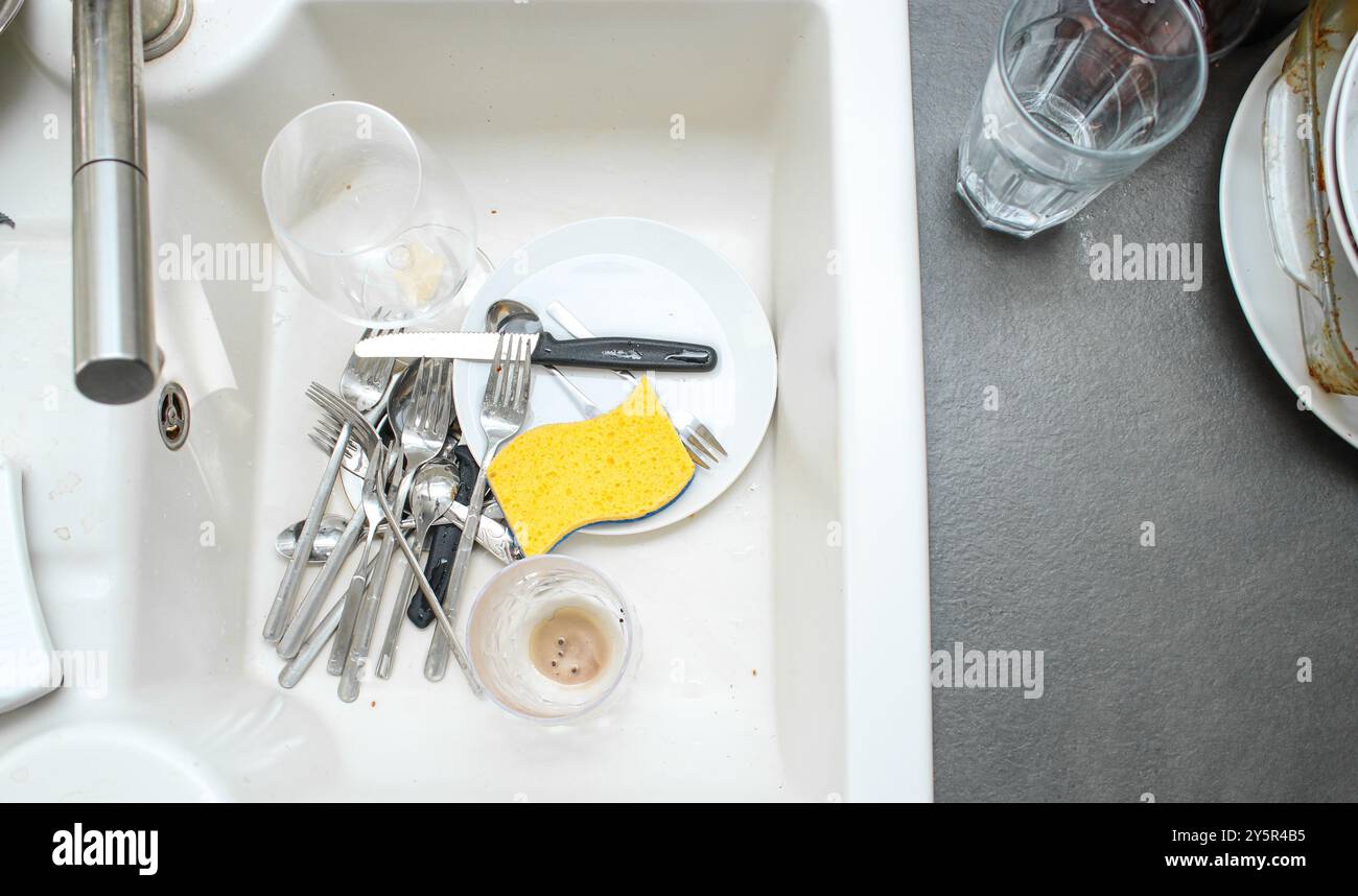 Évier de cuisine en céramique blanc plein de vaisselle sale non lavée Banque D'Images