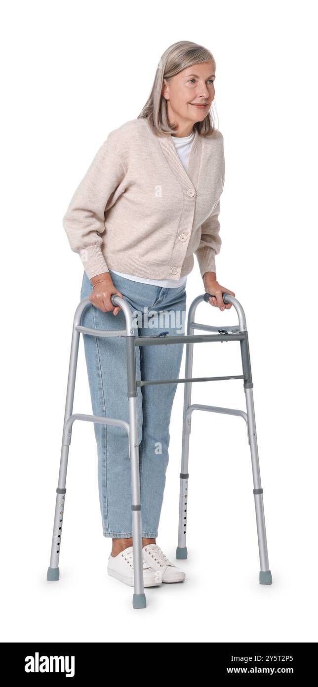 Femme senior utilisant le cadre de marche sur fond blanc Banque D'Images