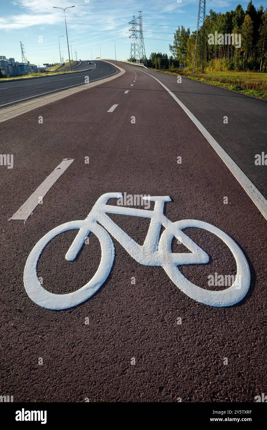 Symbole de vélo blanc frais peint sur le tarmac rouge, Oulu Finlande Banque D'Images