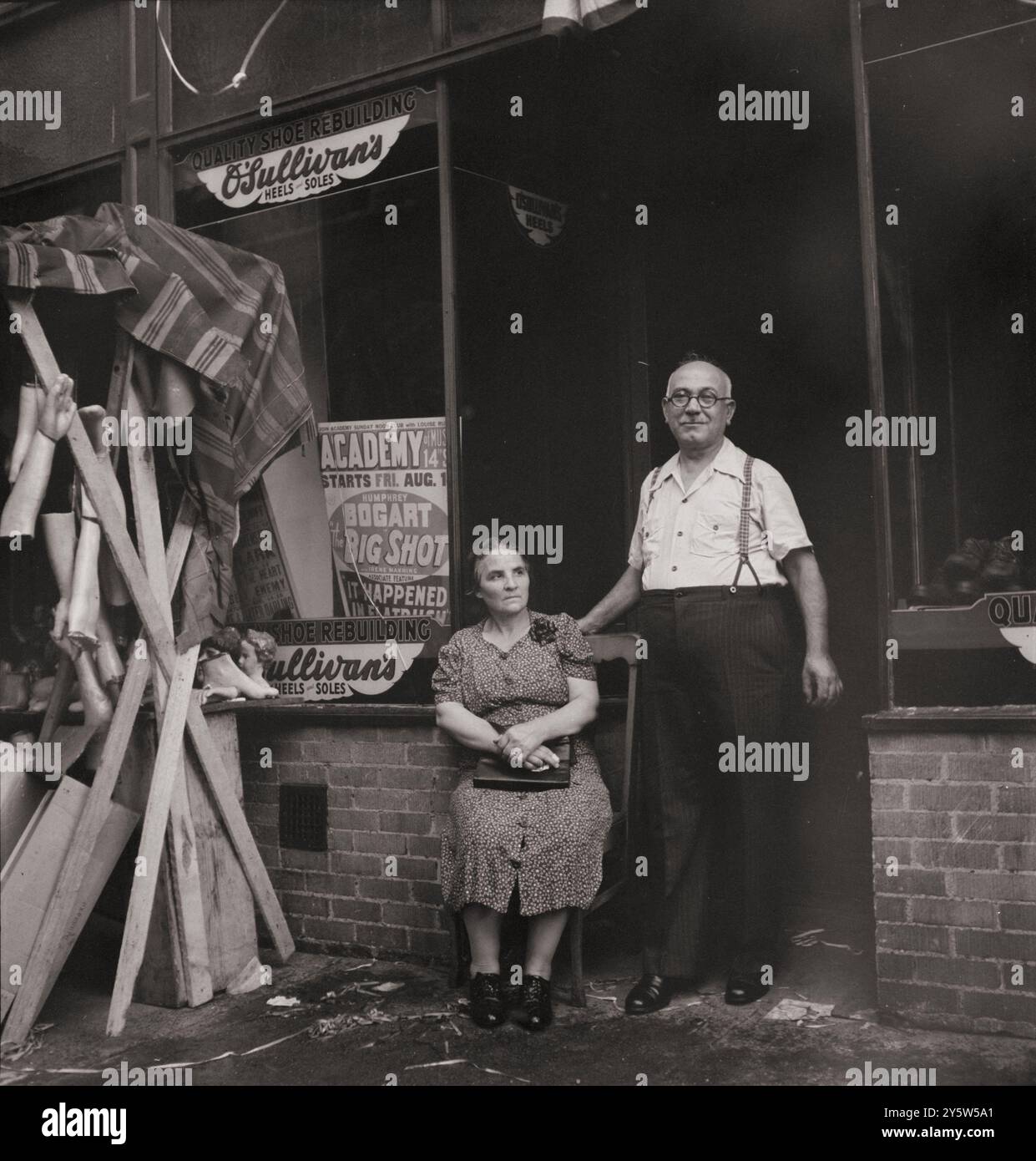 L'Amérique des années 1940 Cordonnier et sa femme dans la section italienne de Mott Street. Était images en l'honneur de la fête de San Rocco à droite. New York. Août 1942 par M. Collins, photographe Banque D'Images