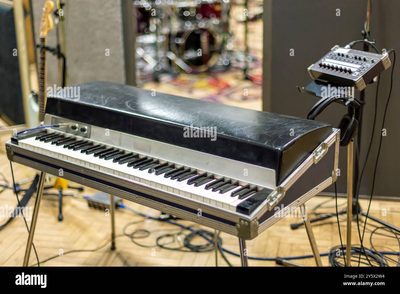 Piano électrique et synthétiseur dans un studio d'enregistrement de musique avec des pieds de microphone et batterie en arrière-plan. Banque D'Images