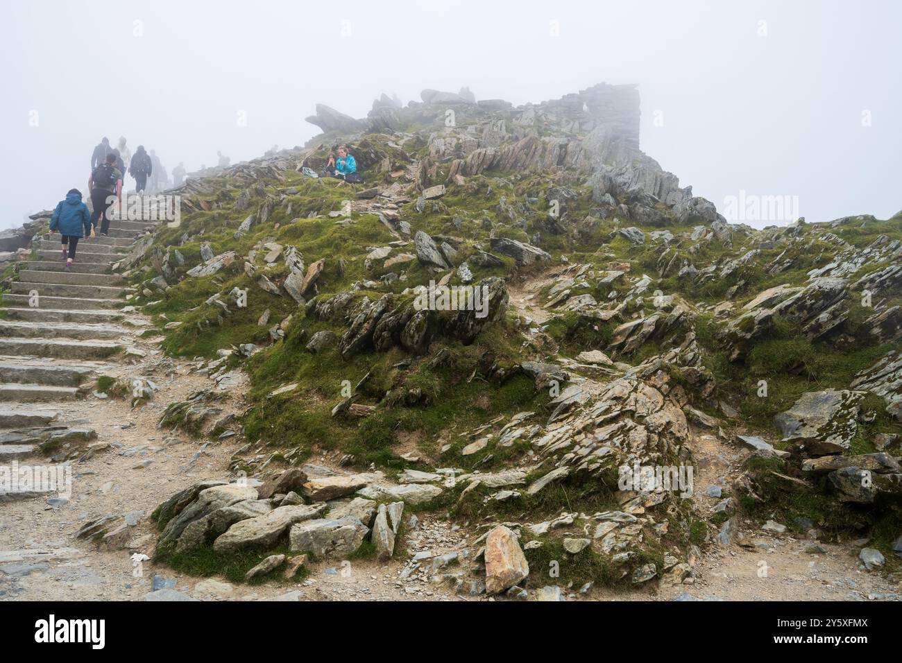 Le sommet du mont Snowdon couvert de nuages avec des marcheurs incapables de voir la vue. Banque D'Images