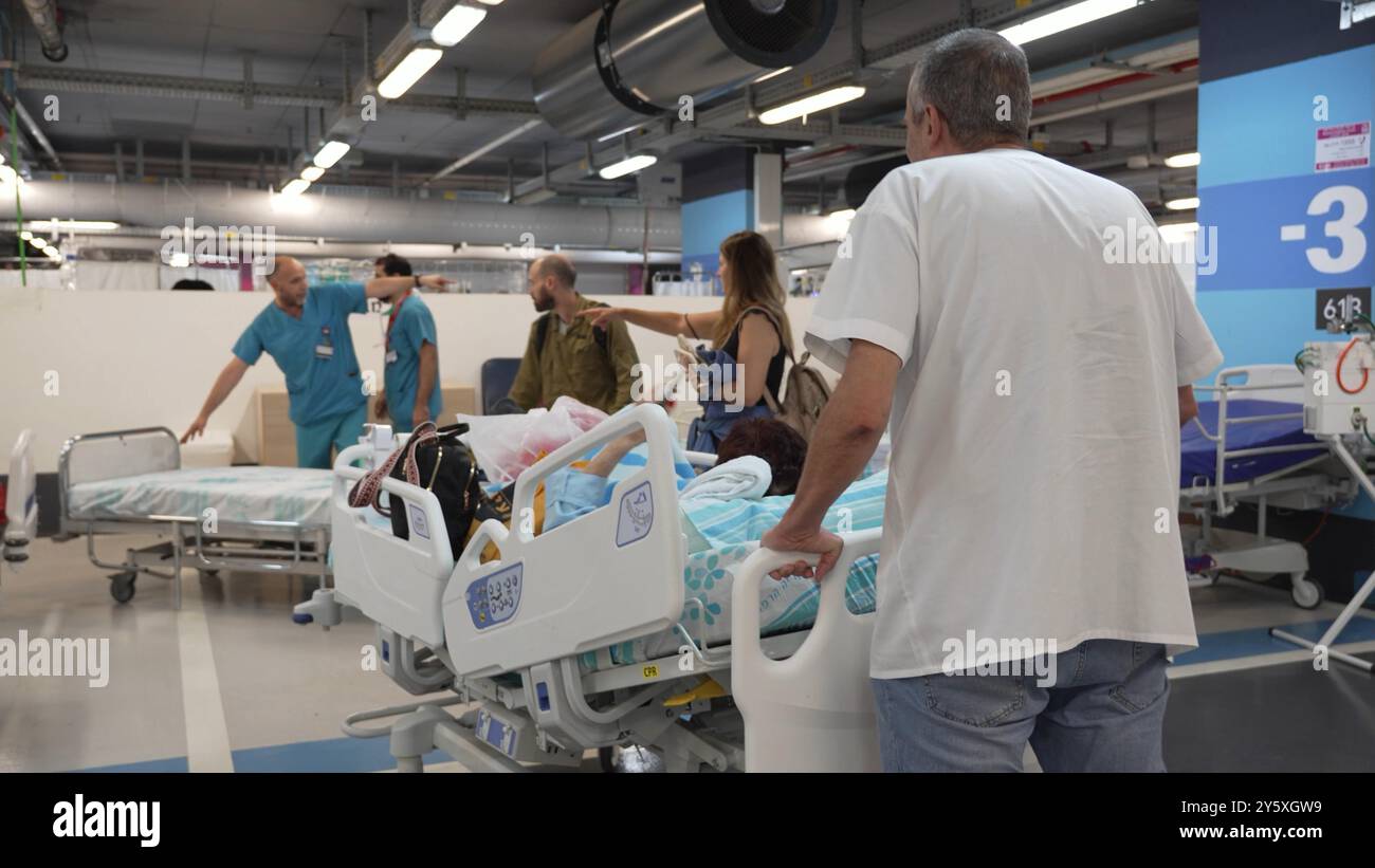 HAÏFA, ISRAËL - 22 SEPTEMBRE : des soldats israéliens et le personnel hospitalier poussent des lits de patients sur le parking souterrain du Centre médical de Rambam après que la direction ait déplacé ses salles et ses patients sous terre à la lumière de la situation sécuritaire et suite aux frappes de missiles depuis le Liban le 22 septembre 2024 à Haïfa, Israël. Banque D'Images