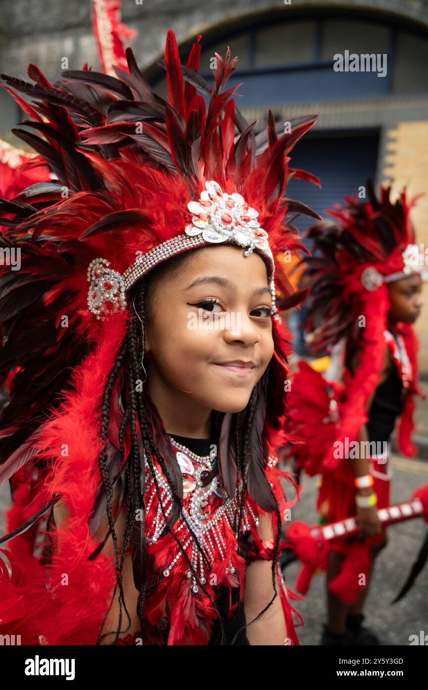 22 septembre 2024 Carnaval de Hackney. Enfant en robe de tête en plumes rouges Banque D'Images