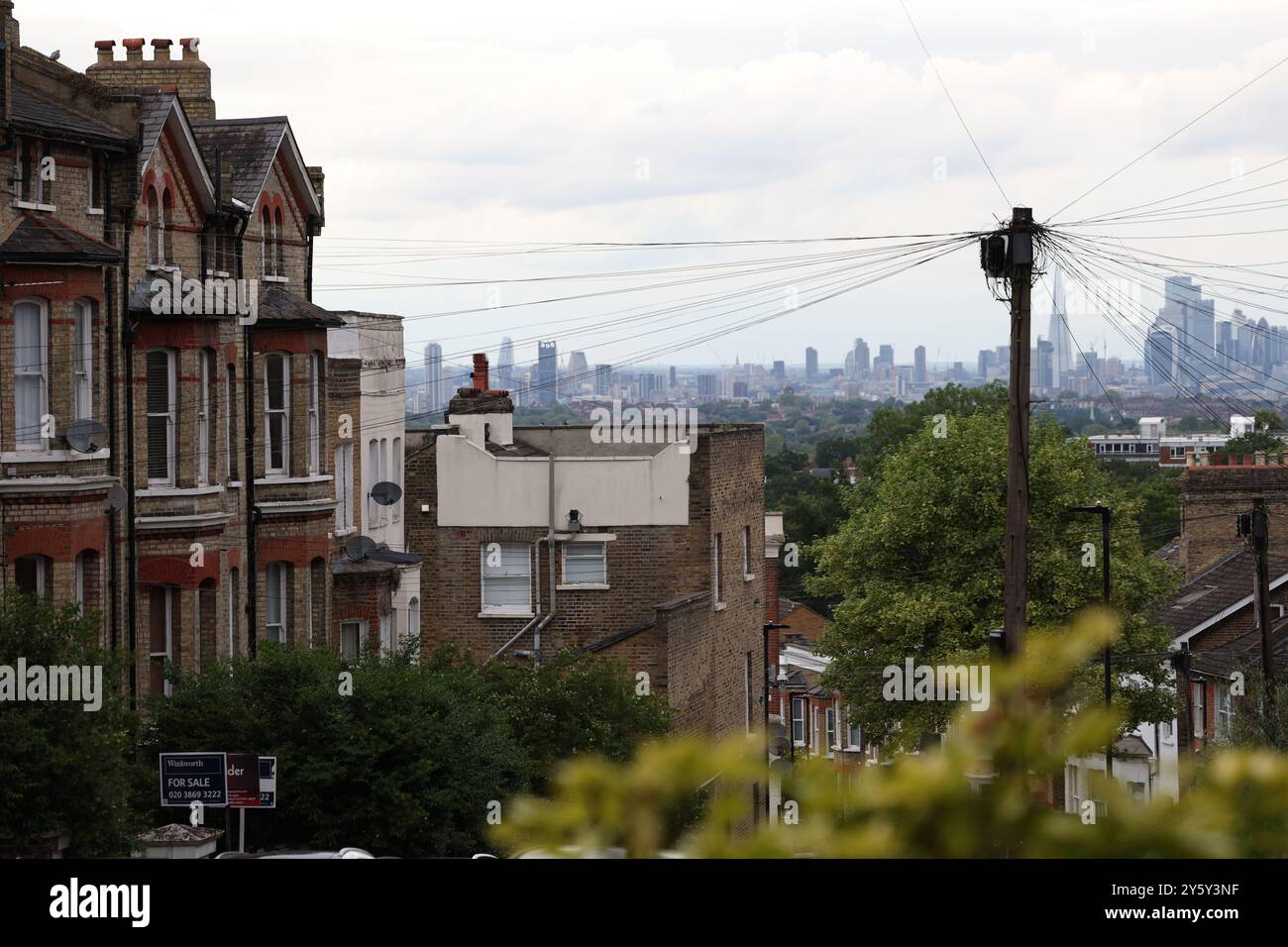 Londres, Royaume-Uni. 11 juin 2024. Une photographie montre l'horizon de la ville et une rangée de maisons dans une rue résidentielle près de Crystal Palace, au sud de Londres. Crédit : Banque D'Images