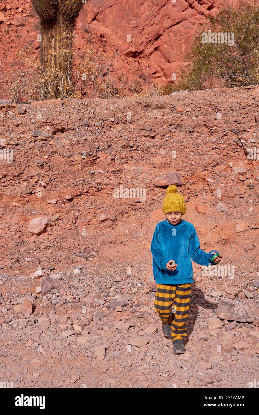 Garçon latino marchant en avant sur une promenade dans les montagnes à Jujuy, dans le nord de l'Argentine. Banque D'Images