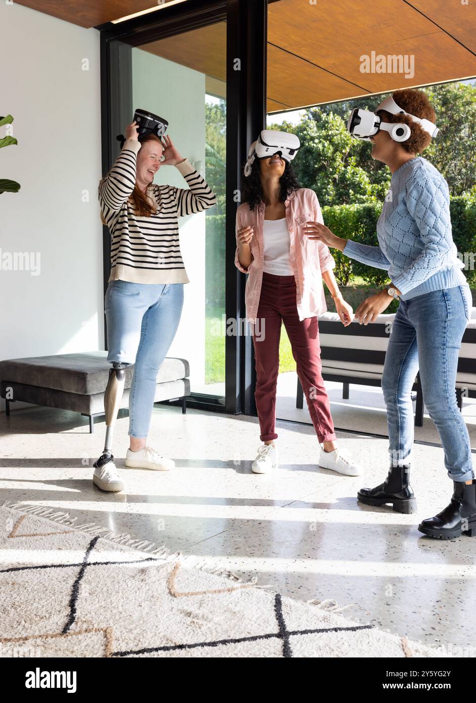 En utilisant des casques VR, diverses femmes amies appréciant l'expérience de réalité virtuelle ensemble Banque D'Images