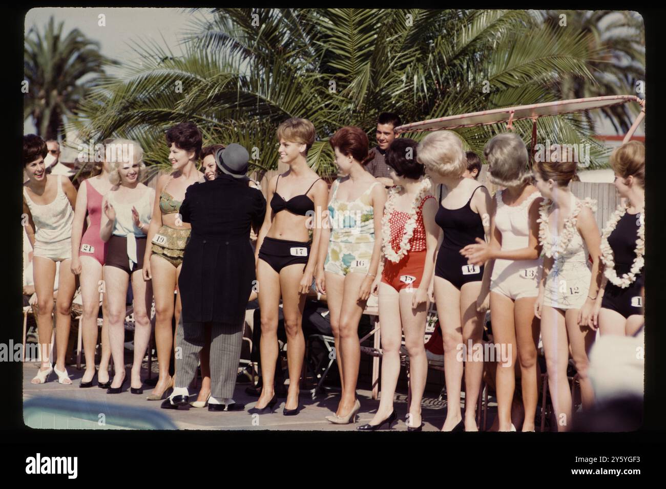 Les participants au concours de beauté au bord de la piscine attendent les résultats dans le cadre ensoleillé des palmiers du sud de la Californie. Banque D'Images
